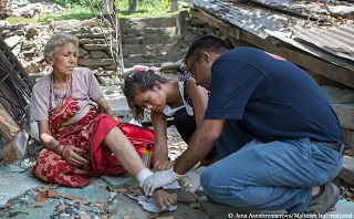 A Malteser International staff member provides aid to a patient wounded in the earthquake. Photo: Jana Asenbrennerova