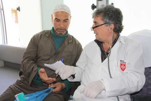 Dr. Abdallah untersucht eine Flüchtlingsfamilie in Wadi Khaled. /Dr. Abdallah examines a refugee family in Wadi Khaled.