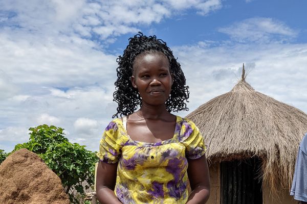 Tumalu Beatrice vor ihrem Haus in Uganda