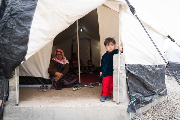 Geflüchtetes Kind vor einem Zelt im Flüchtlingslager