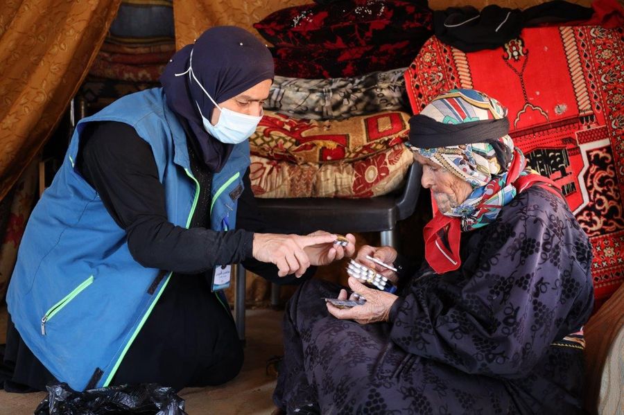 Khatma Al-Issa is visited by an aid worker.