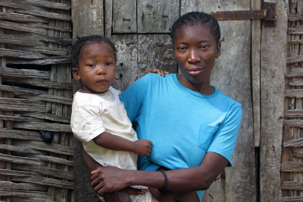 Mutter und Kind auf Haiti vor ihrem vom Hurrikan zerstörtem Haus